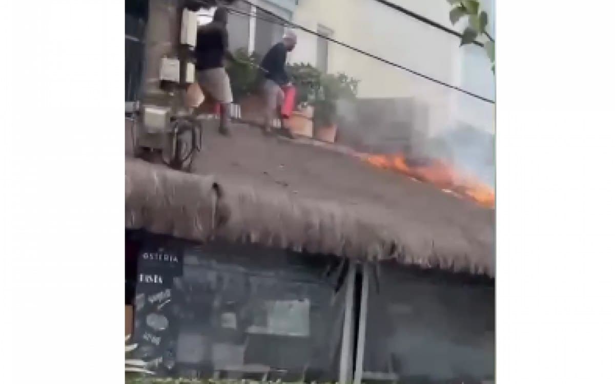 Fire hits the thatched roof of a restaurant on Orla Bardot, in Búzios